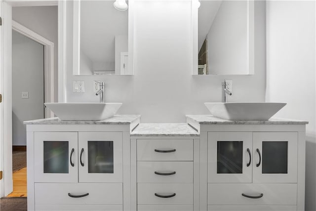 full bathroom with a sink and two vanities