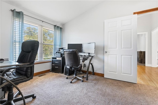 office space with baseboards, carpet, and vaulted ceiling