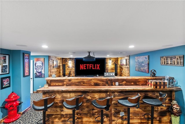 bar featuring bar area, recessed lighting, baseboards, and carpet floors