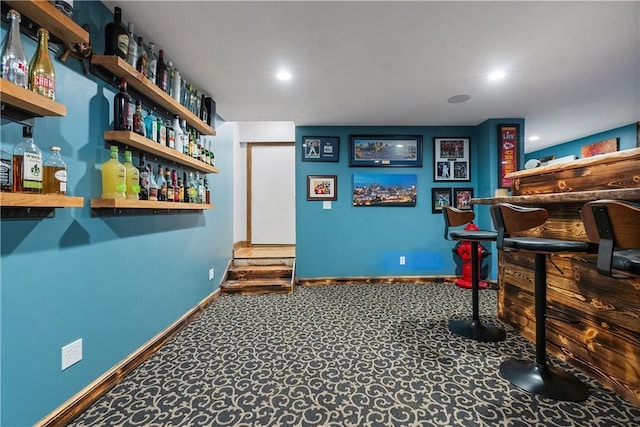 game room featuring recessed lighting, baseboards, a bar, and carpet floors