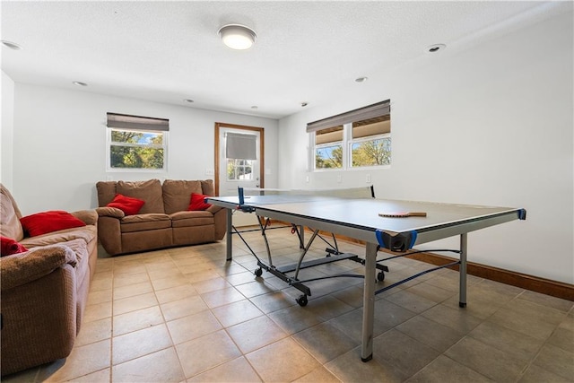 playroom featuring a wealth of natural light, baseboards, a textured ceiling, and light tile patterned flooring