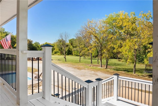 deck with a fenced in pool and a lawn