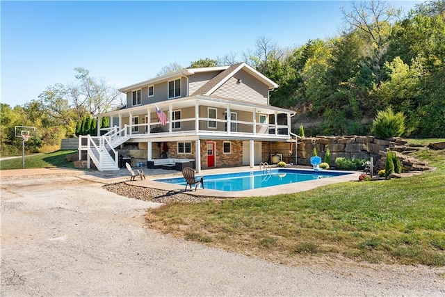 back of property with a fenced in pool, stairs, a yard, a patio area, and stone siding