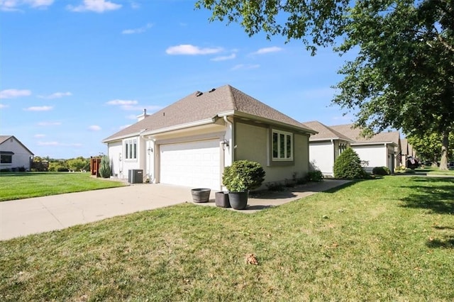 view of side of property with a garage, a yard, and central air condition unit