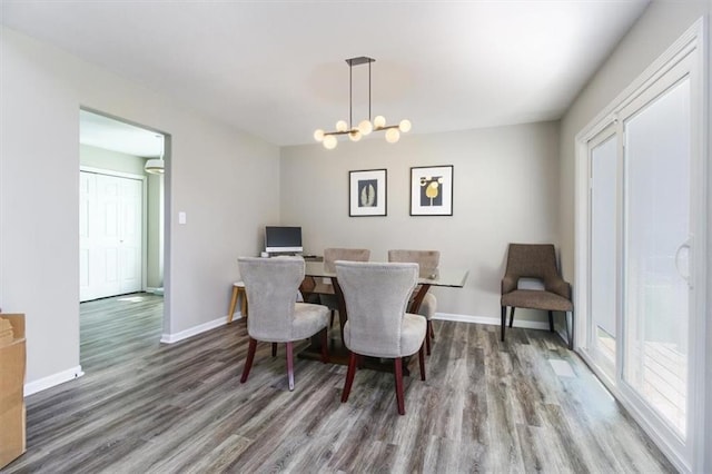 dining area with wood-type flooring and a notable chandelier