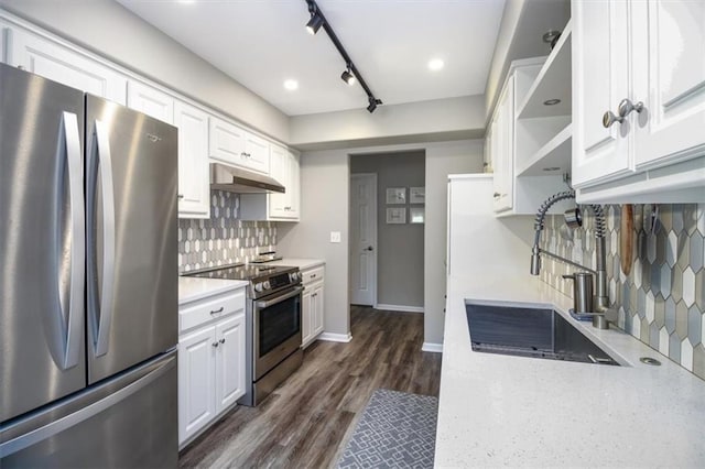 kitchen with appliances with stainless steel finishes, tasteful backsplash, sink, white cabinets, and dark hardwood / wood-style floors