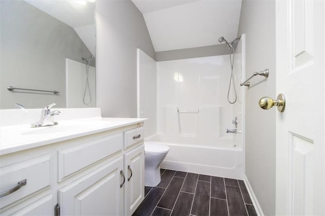 full bathroom featuring  shower combination, vanity, hardwood / wood-style floors, toilet, and lofted ceiling