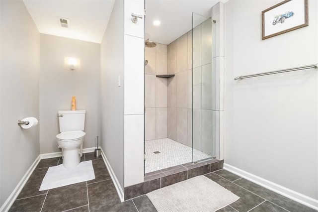 bathroom featuring tile patterned floors, toilet, and tiled shower