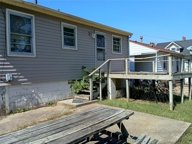 rear view of house featuring a wooden deck