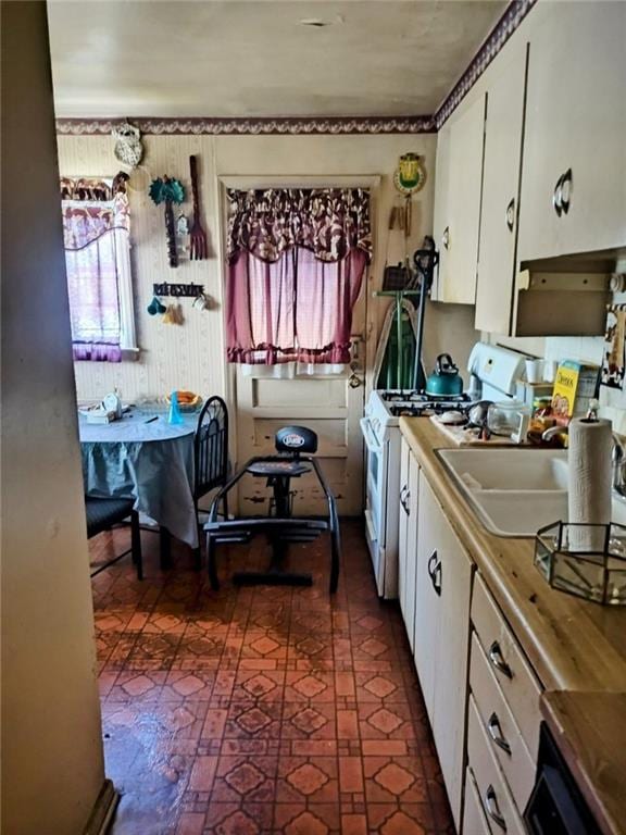 kitchen with white cabinetry and white range with gas stovetop