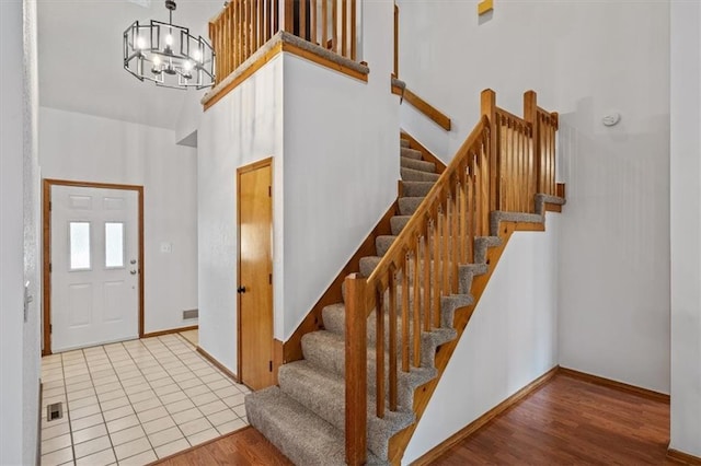 foyer featuring light hardwood / wood-style floors, a high ceiling, and an inviting chandelier