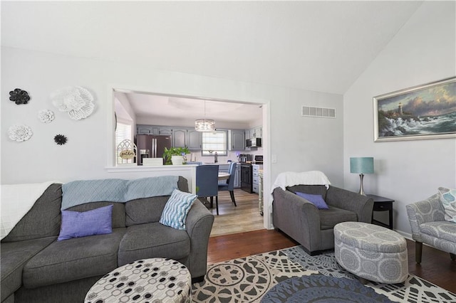 living room with dark hardwood / wood-style flooring and vaulted ceiling