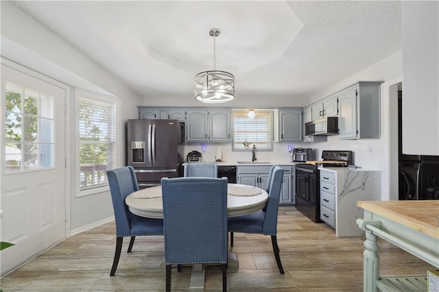 dining area featuring a wealth of natural light, light hardwood / wood-style flooring, and a chandelier