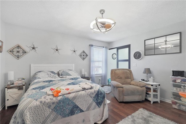 bedroom with a textured ceiling and dark wood-type flooring