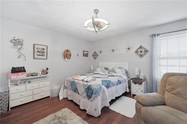 bedroom with dark hardwood / wood-style flooring and a textured ceiling