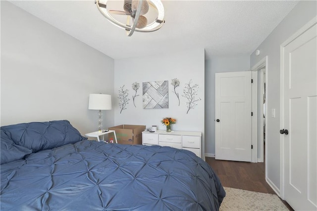 bedroom with a textured ceiling and dark hardwood / wood-style floors