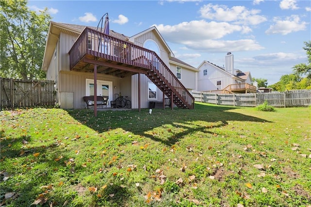 back of property featuring a lawn and a deck