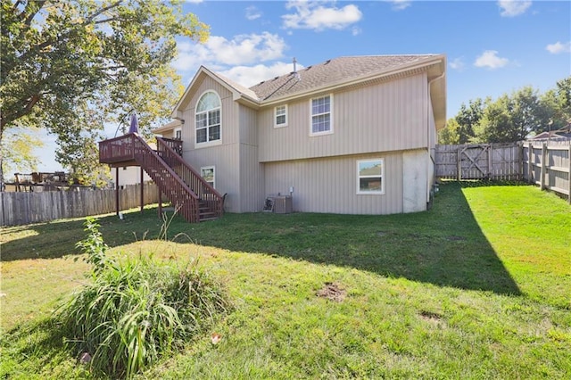 rear view of property with a yard, central AC unit, and a wooden deck