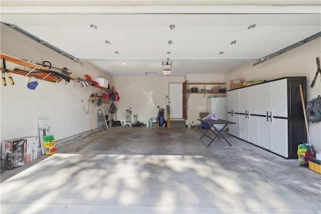 garage with white fridge and a garage door opener