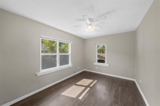 empty room with plenty of natural light, dark hardwood / wood-style flooring, a textured ceiling, and ceiling fan