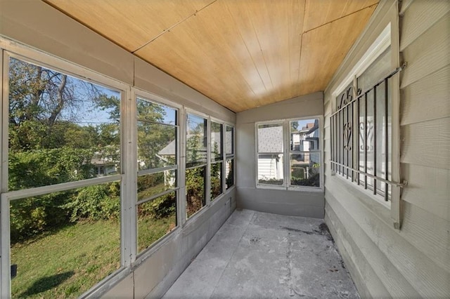 unfurnished sunroom with wooden ceiling, vaulted ceiling, and a wealth of natural light