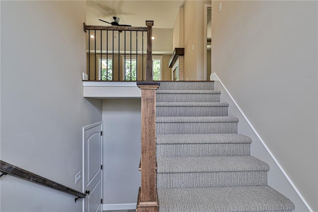 staircase featuring ceiling fan