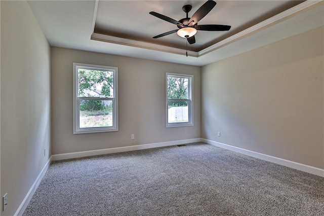 unfurnished room with ornamental molding, carpet flooring, a tray ceiling, and ceiling fan