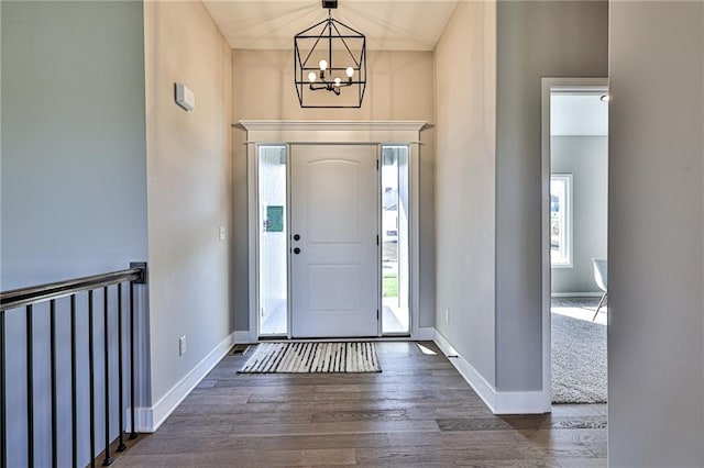 foyer entrance featuring an inviting chandelier and dark wood-type flooring