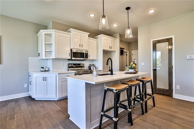 kitchen featuring appliances with stainless steel finishes, sink, dark hardwood / wood-style flooring, and white cabinets