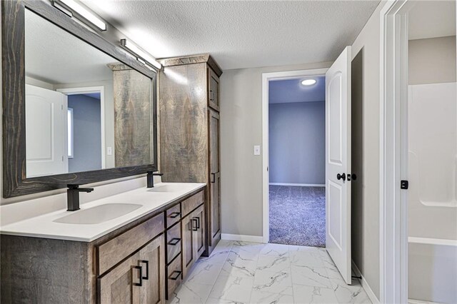 bathroom with a textured ceiling and vanity