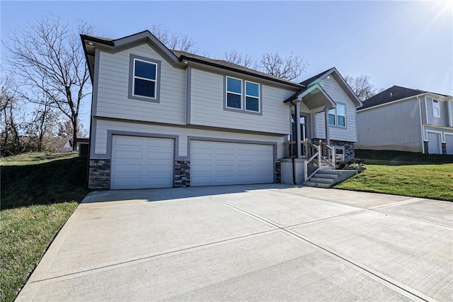 bi-level home with stone siding, an attached garage, concrete driveway, and a front yard