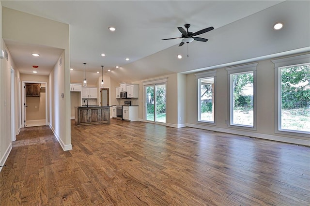 unfurnished living room with vaulted ceiling, recessed lighting, baseboards, dark wood-style floors, and a ceiling fan