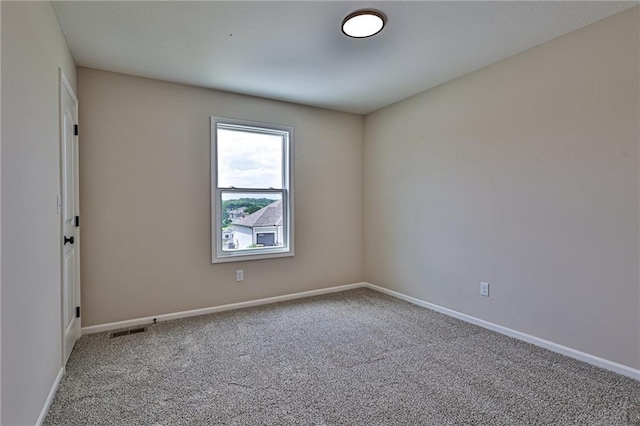 empty room featuring baseboards, visible vents, and carpet