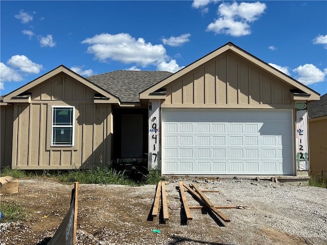 ranch-style home with driveway, board and batten siding, an attached garage, and roof with shingles