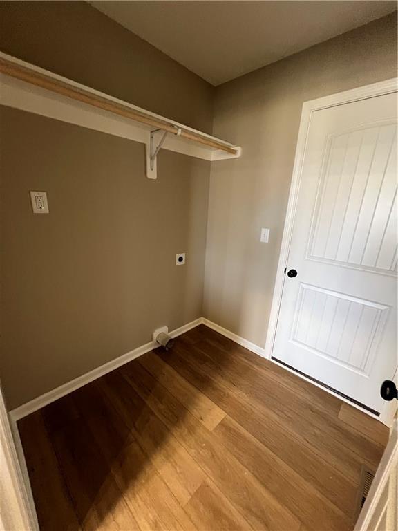 clothes washing area featuring wood-type flooring and hookup for an electric dryer