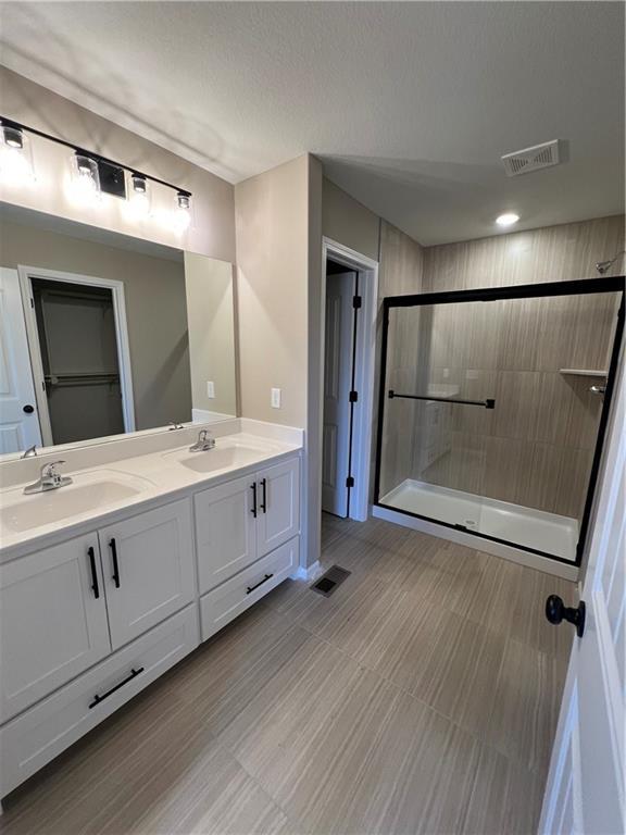 bathroom with vanity and a shower with shower door