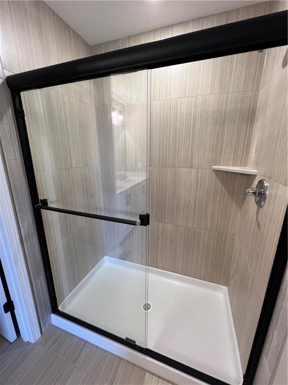 bathroom featuring a shower with shower door