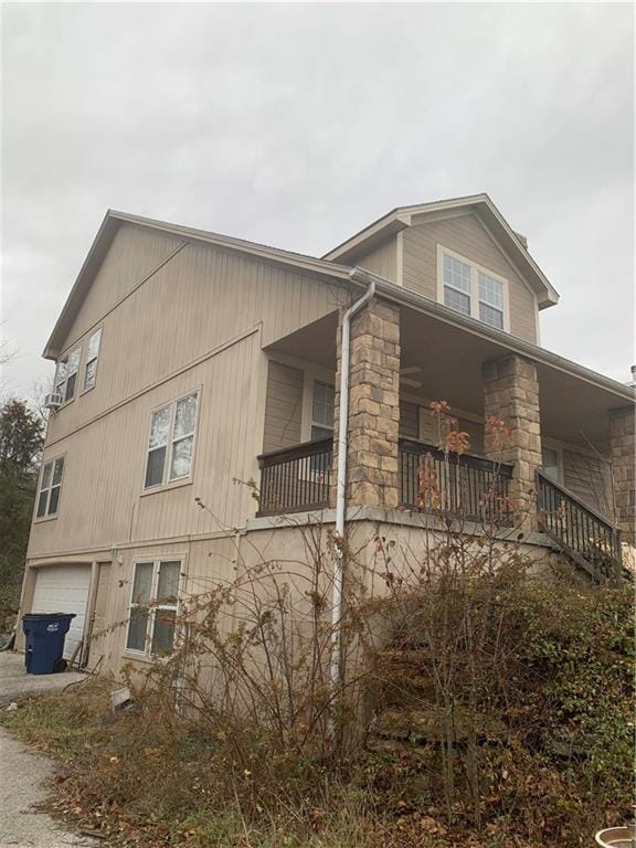 view of side of home with covered porch and a garage