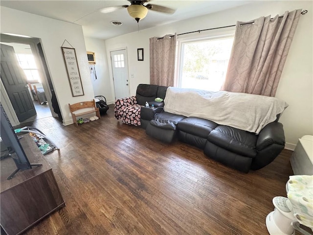 living room featuring ceiling fan and dark hardwood / wood-style floors