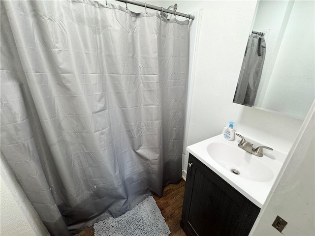 bathroom featuring hardwood / wood-style flooring, vanity, and curtained shower