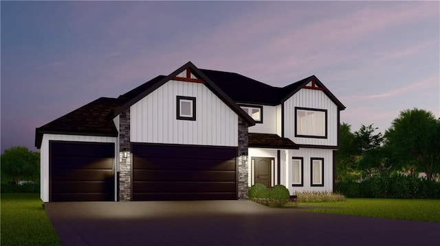 view of front of home featuring board and batten siding, driveway, stone siding, and a lawn