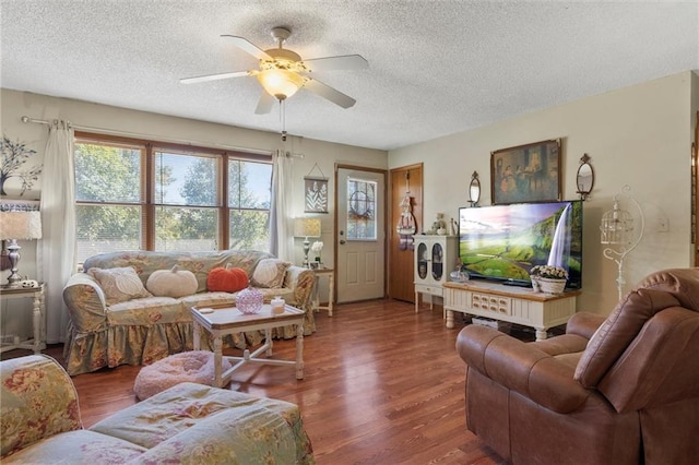 living room with ceiling fan, a textured ceiling, and dark hardwood / wood-style flooring