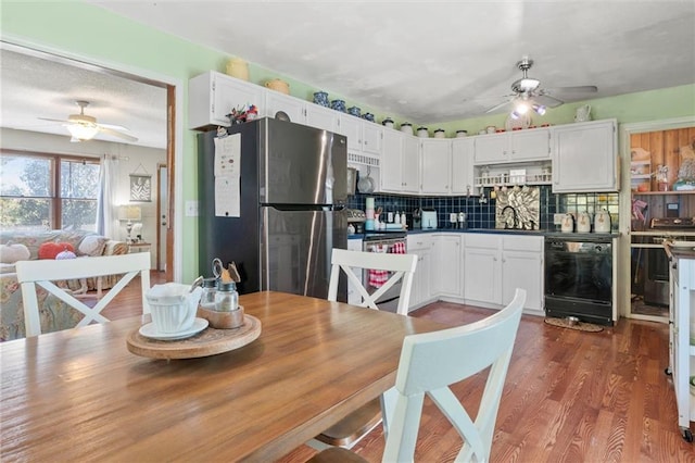 kitchen featuring white cabinets, appliances with stainless steel finishes, dark hardwood / wood-style flooring, and tasteful backsplash