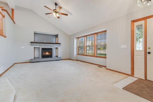 unfurnished living room featuring ceiling fan, a tiled fireplace, carpet flooring, and high vaulted ceiling