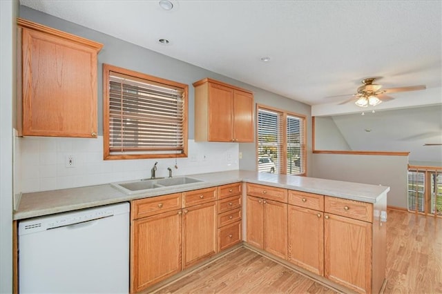 kitchen featuring ceiling fan, sink, kitchen peninsula, dishwasher, and light hardwood / wood-style floors