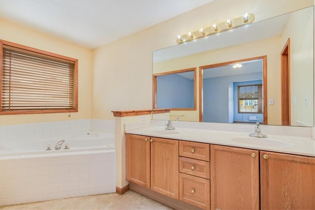 bathroom featuring a relaxing tiled tub and vanity