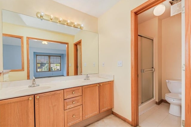 bathroom featuring vanity, a shower with shower door, toilet, and tile patterned flooring