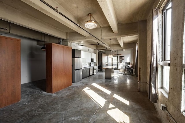 interior space with a healthy amount of sunlight, sink, and beamed ceiling