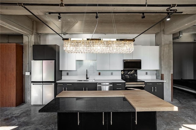 kitchen featuring stainless steel appliances, a center island, and white cabinetry