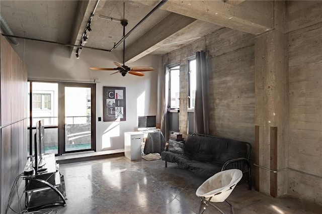 sitting room with rail lighting, ceiling fan, and concrete flooring